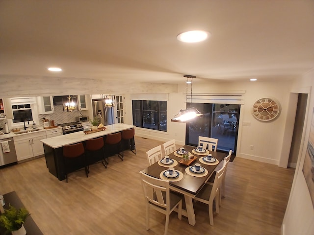 dining room featuring recessed lighting, baseboards, an inviting chandelier, and wood finished floors