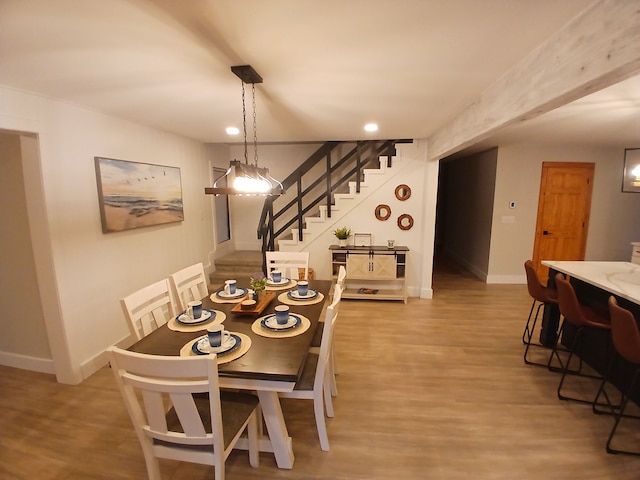 dining space with recessed lighting, baseboards, light wood-style floors, and stairs