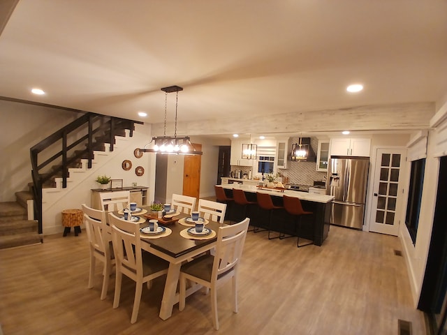 dining space featuring visible vents, recessed lighting, stairs, and light wood-style floors