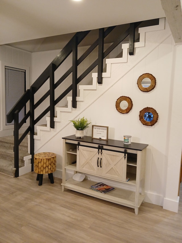 staircase with baseboards and wood finished floors