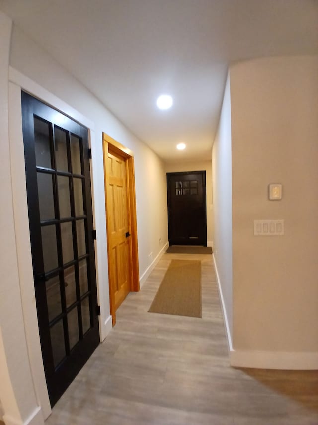 hall with recessed lighting, wood finished floors, and baseboards