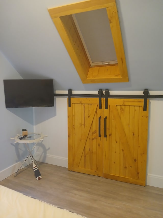 details with a barn door, baseboards, and wood finished floors