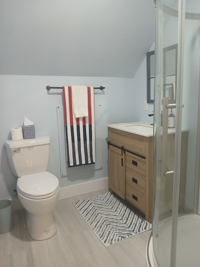 full bathroom featuring vanity, baseboards, lofted ceiling, a stall shower, and toilet