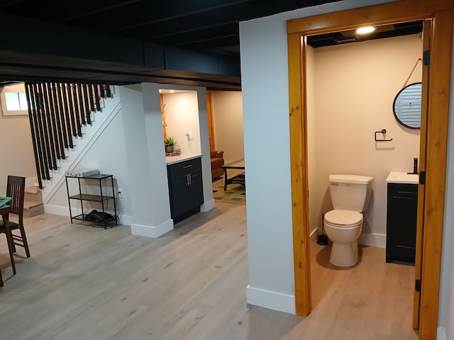 basement with light wood finished floors, stairway, and baseboards