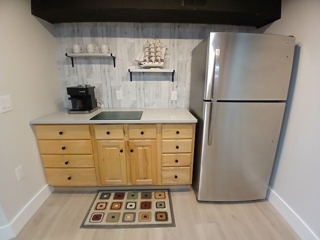 kitchen with light wood finished floors, light countertops, freestanding refrigerator, and open shelves