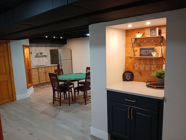 interior space with baseboards, light wood-style floors, and freestanding refrigerator