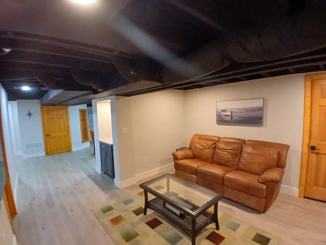 living room featuring visible vents, baseboards, and light wood-style floors