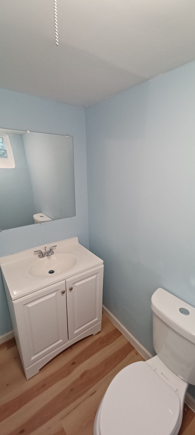 bathroom featuring toilet, vanity, and hardwood / wood-style flooring