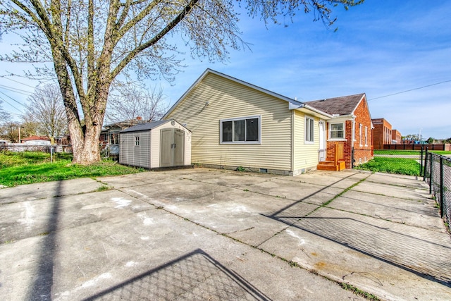 rear view of property featuring a storage unit