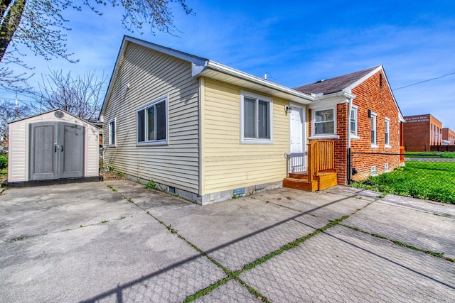 rear view of house featuring a storage shed and a patio area