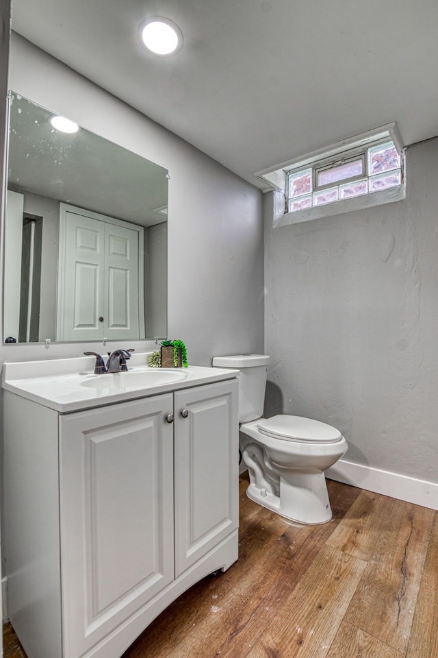 bathroom featuring vanity, wood-type flooring, and toilet