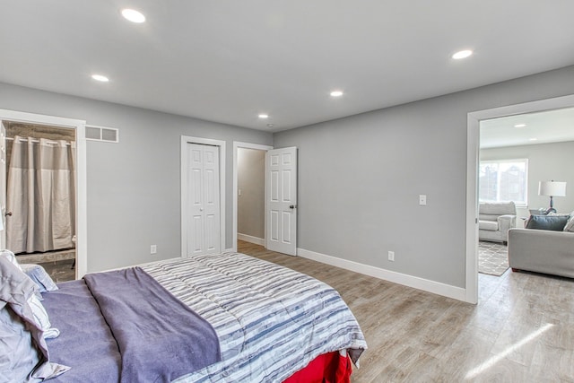 bedroom with connected bathroom and light wood-type flooring