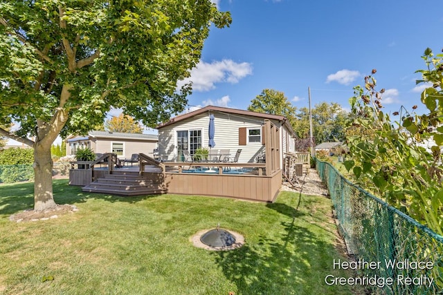 back of house featuring a lawn and a deck