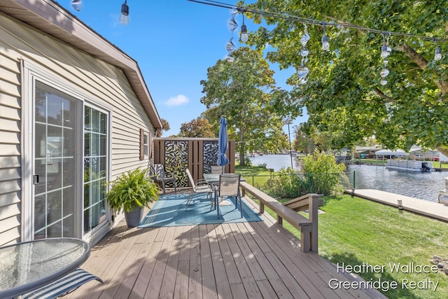 deck with a water view and a yard