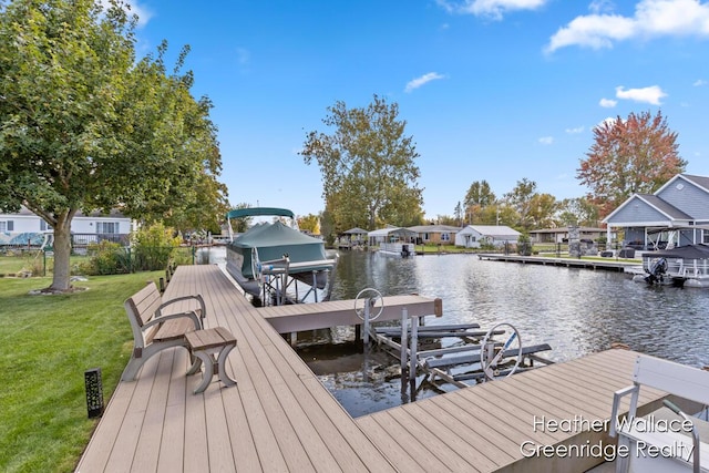 view of dock featuring a water view and a yard