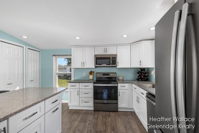 kitchen with sink, dark hardwood / wood-style flooring, light stone counters, white cabinetry, and stainless steel appliances