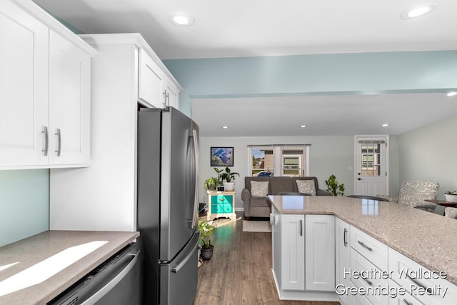 kitchen with light stone countertops, dark hardwood / wood-style flooring, white cabinets, and appliances with stainless steel finishes