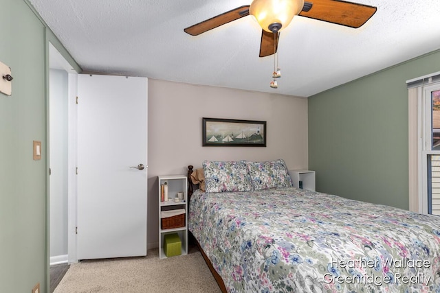 carpeted bedroom with a textured ceiling and ceiling fan