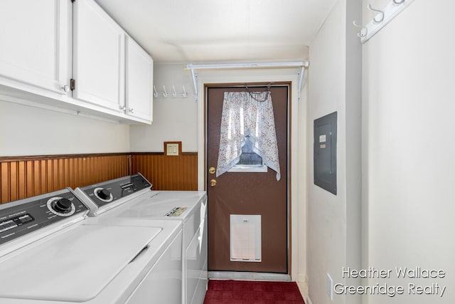 clothes washing area featuring cabinets, electric panel, washer and dryer, and wooden walls