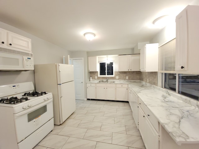 kitchen featuring white cabinetry, sink, backsplash, and white appliances