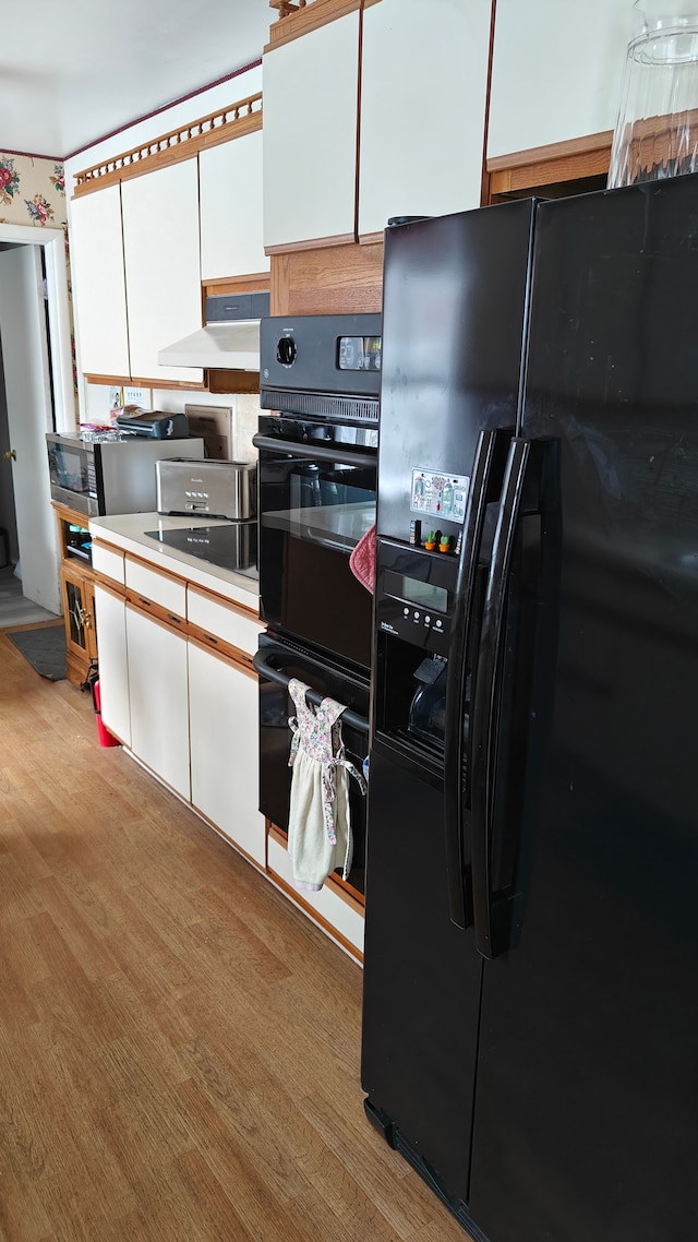 3624 Evergreen Pkwy, Flint, MI 48503 - kitchen with stovetop, light hardwood / wood-style floors, white cabinetry, and black refrigerator with ice dispenser