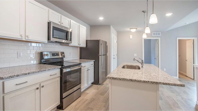 kitchen featuring sink, white cabinets, an island with sink, hanging light fixtures, and appliances with stainless steel finishes