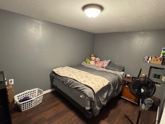 bedroom with dark wood-type flooring and a textured ceiling