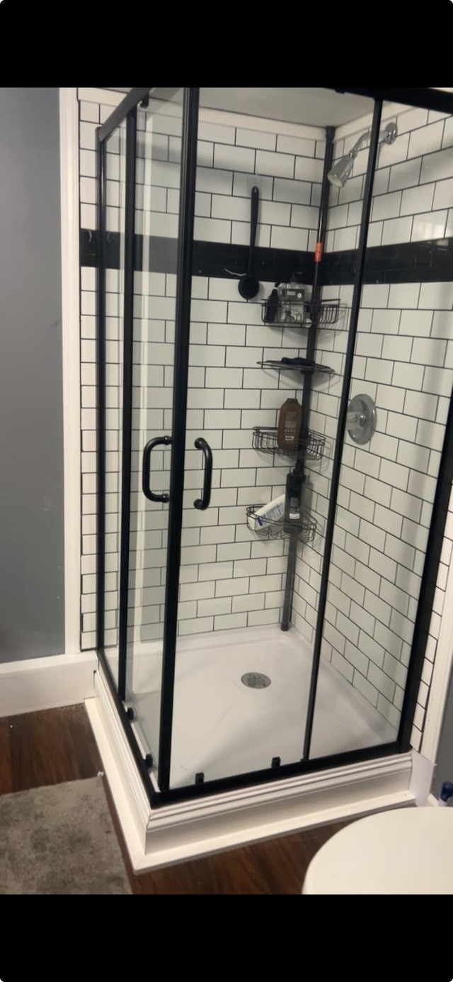 bathroom featuring an enclosed shower and hardwood / wood-style floors