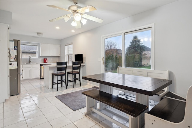 dining space featuring ceiling fan, light tile patterned floors, and sink