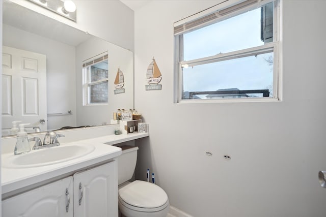 bathroom with a wealth of natural light, vanity, and toilet