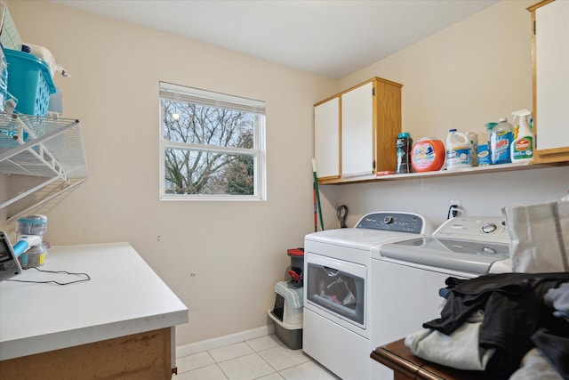 washroom featuring cabinets, light tile patterned floors, and washing machine and dryer