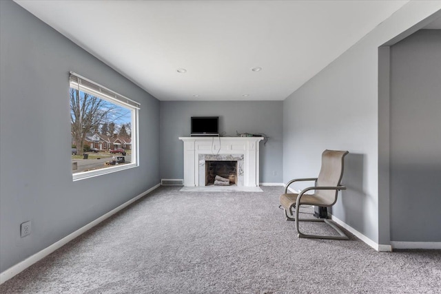 sitting room with a fireplace and light carpet