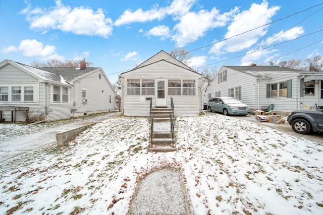 snow covered property featuring a sunroom