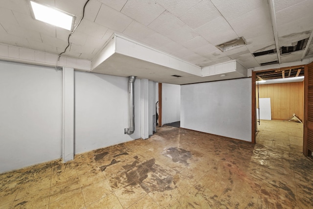 basement featuring wooden walls