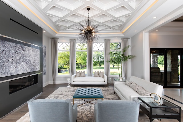 living room with coffered ceiling, crown molding, wood-type flooring, a notable chandelier, and beamed ceiling