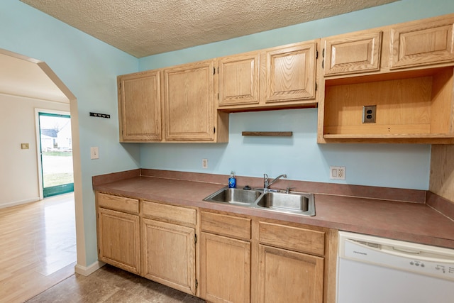 kitchen with light brown cabinetry, dishwasher, sink, light hardwood / wood-style floors, and a textured ceiling