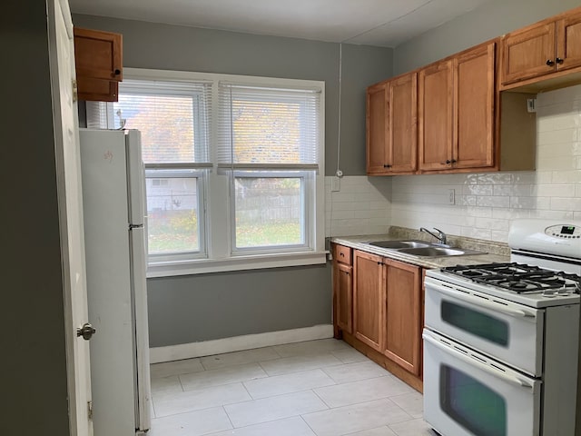 kitchen featuring decorative backsplash, sink, a healthy amount of sunlight, and white appliances