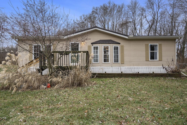 rear view of house featuring a lawn and a wooden deck