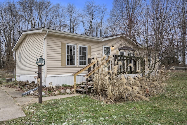 manufactured / mobile home featuring a front yard and a deck