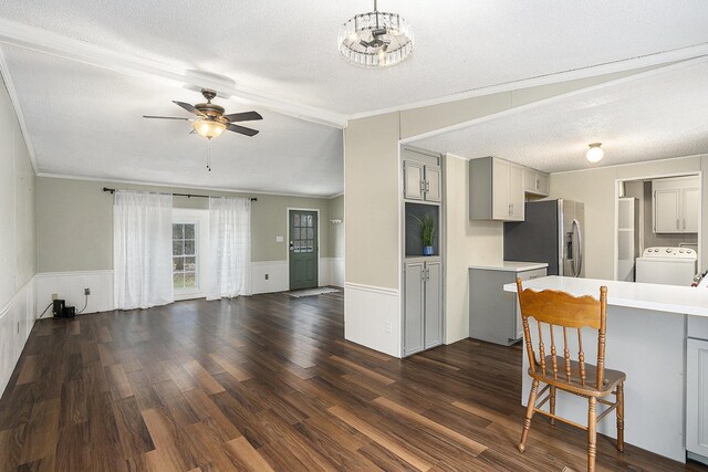 kitchen featuring gray cabinetry, ceiling fan, dark wood-type flooring, stainless steel fridge with ice dispenser, and washer / clothes dryer