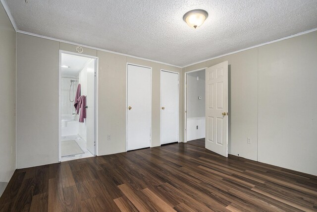 unfurnished bedroom featuring dark wood-type flooring, a textured ceiling, and ornamental molding