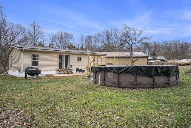 back of house with a lawn and a swimming pool side deck