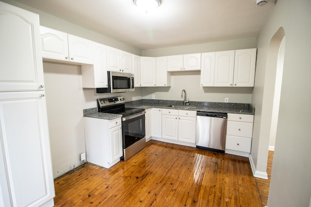 kitchen with sink, white cabinetry, dark wood-type flooring, and appliances with stainless steel finishes