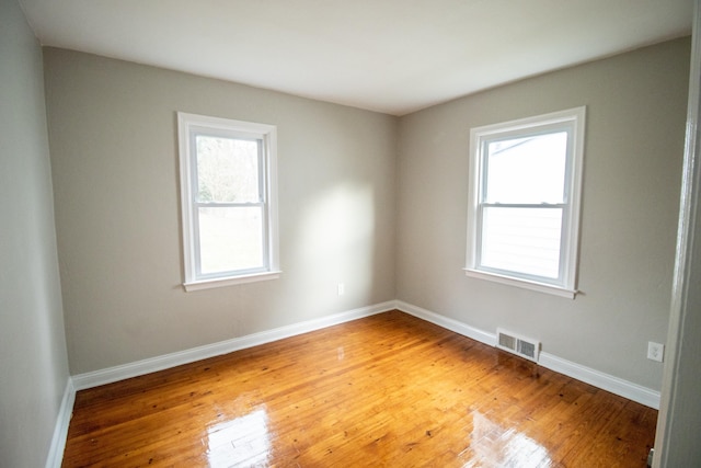 empty room with wood-type flooring and plenty of natural light