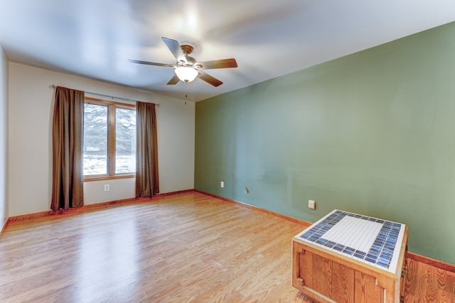 spare room with ceiling fan and light wood-type flooring