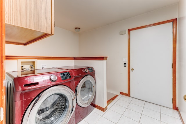 clothes washing area featuring washing machine and dryer and light tile patterned floors