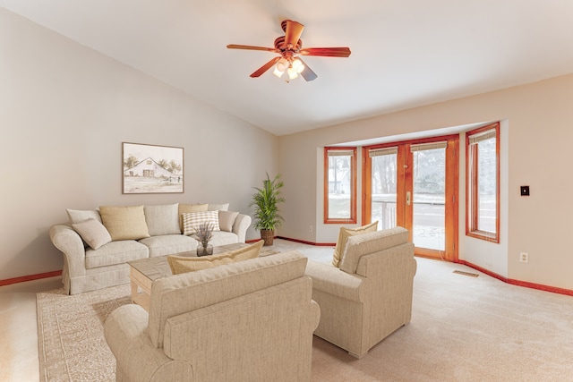 living room with ceiling fan, light colored carpet, and vaulted ceiling