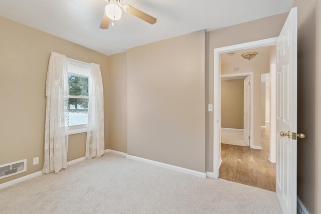 carpeted empty room featuring ceiling fan