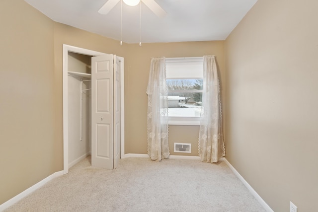 unfurnished bedroom featuring ceiling fan, a closet, and light colored carpet