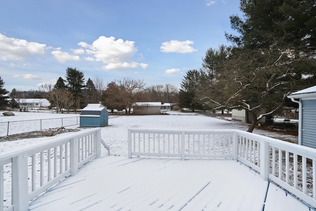 yard layered in snow with a shed and a deck